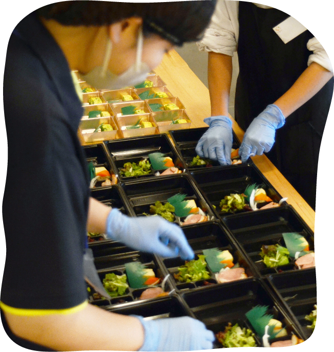 共同でお弁当を詰めている様子